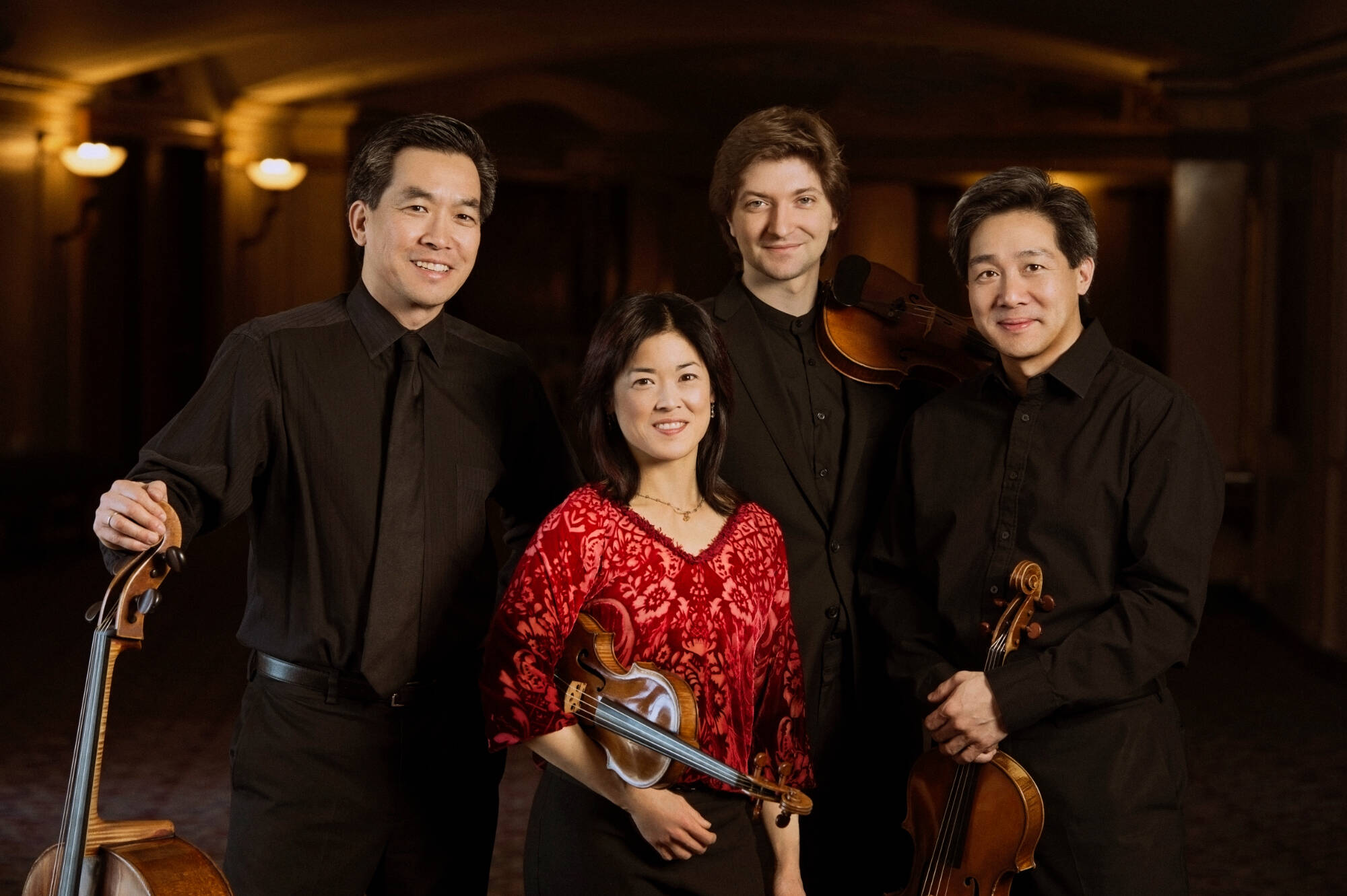 four musicians hold stringed instruments